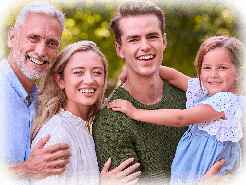 Happy multi-generational family smiling outdoors — family dentistry in Cornwall
