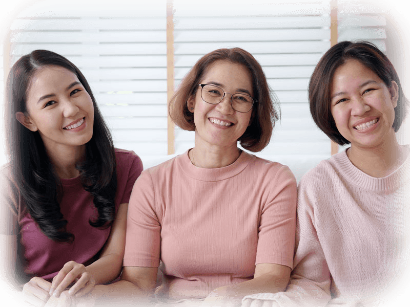 Three smiling women together — healthy gums and confident smiles