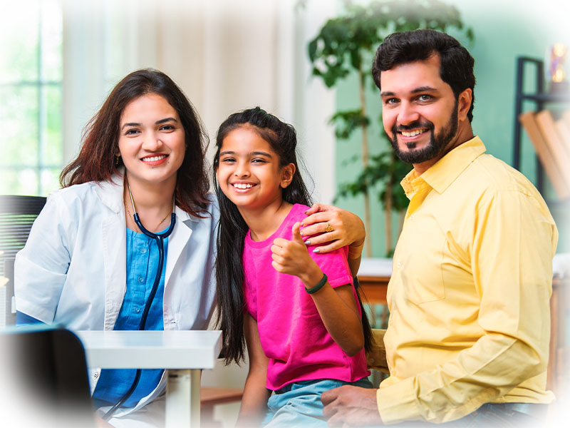 Dentist giving a thumbs up with a happy child and parent in the office
