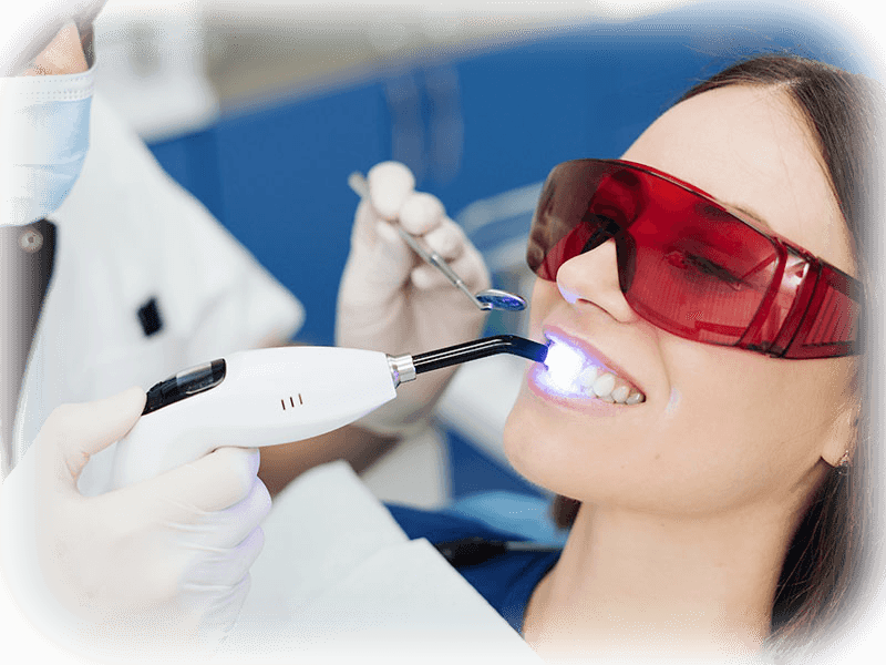 Dentist performing a soft-tissue dental laser treatment with protective eyewear